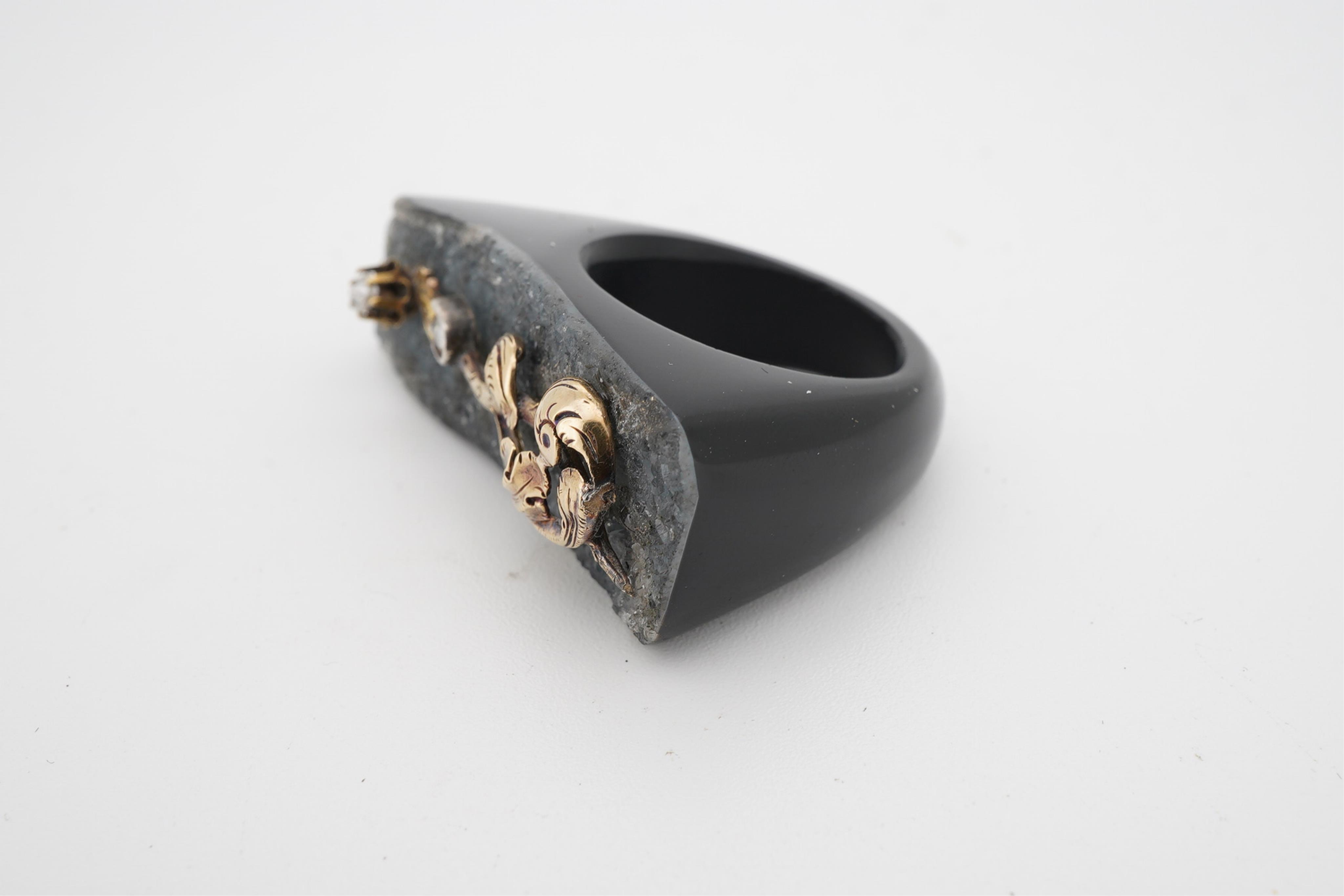 An unusual quartz ring, with a yellow metal and two stone diamond set scrolling foliate surmount, size N/O.